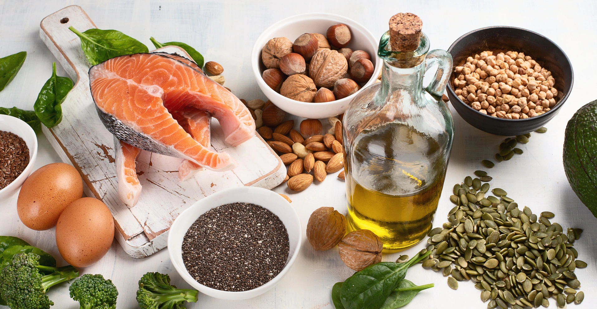 Jaki olej ma najwięcej kwasów omega-3? Źródła omega-3 w pożywieniu na białym blacie - oleje, nasiona, ryby.