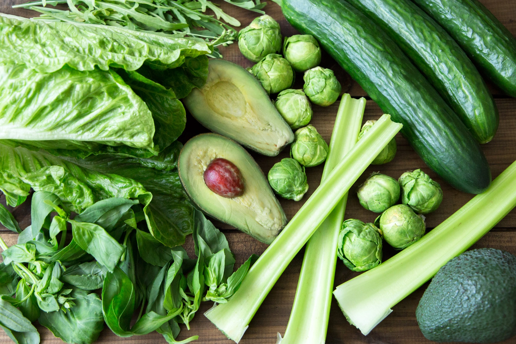 Co warto wiedzieć o kwasie foliowym? Zielone warzywa bogate w foliany leżą na drewnianym stole.