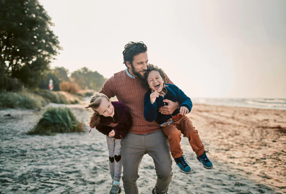 szczęśliwy ojciec z dziećmi na plaży